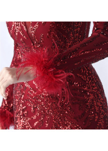 Vestido de noche resplandeciente en rojo burdeos con acentos de plumas